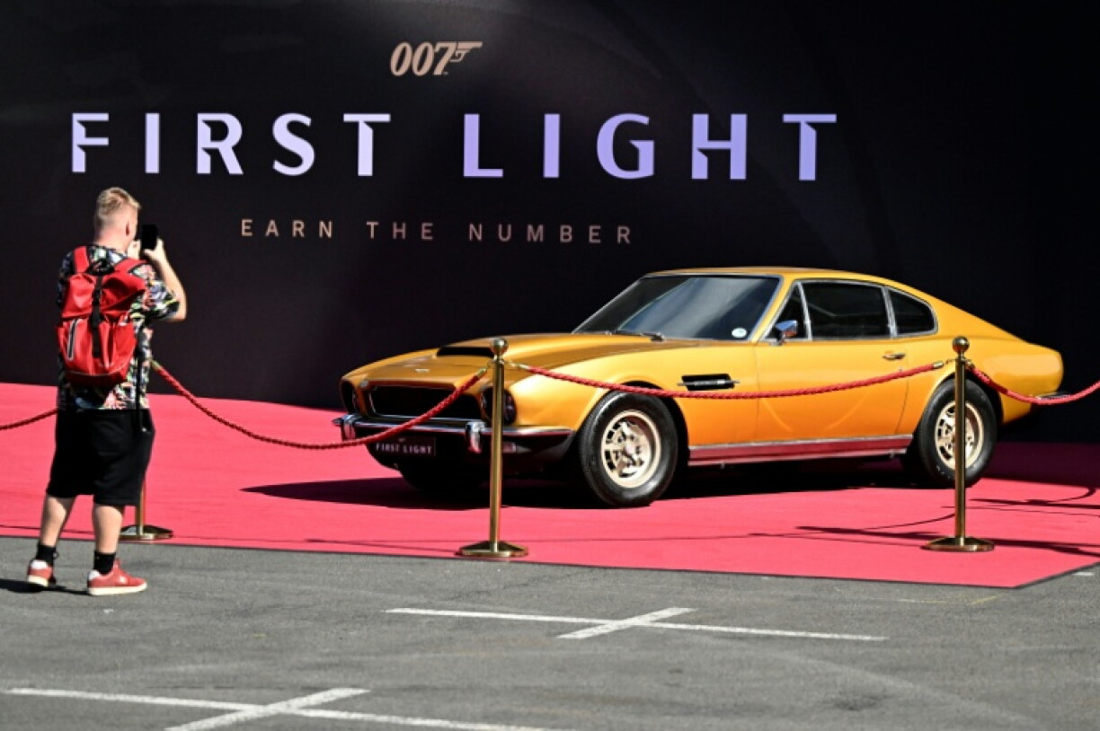 Un visiteur prend en photo une Aston Martin sur le stand du jeu vidéo 007 First Light d'IO Interactive lors du salon Gamescom à Cologne, le 21 août 2025 en Allemane