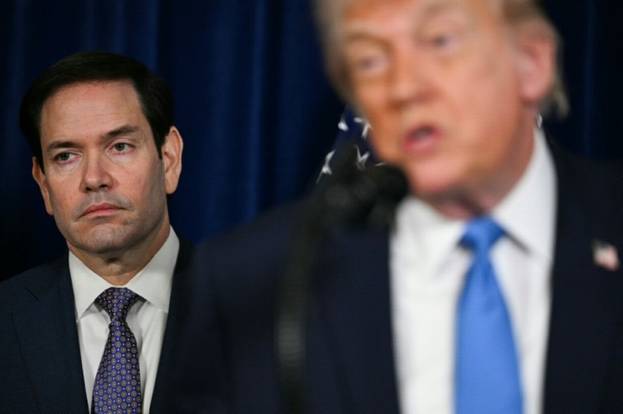 Le secrétaire d'Etat américain Marco Rubio (gauche) écoute le président américain Donald Trump s'adresser à la presse, le 3 janvier 2026 à Palm Beach aux Etats-Unis