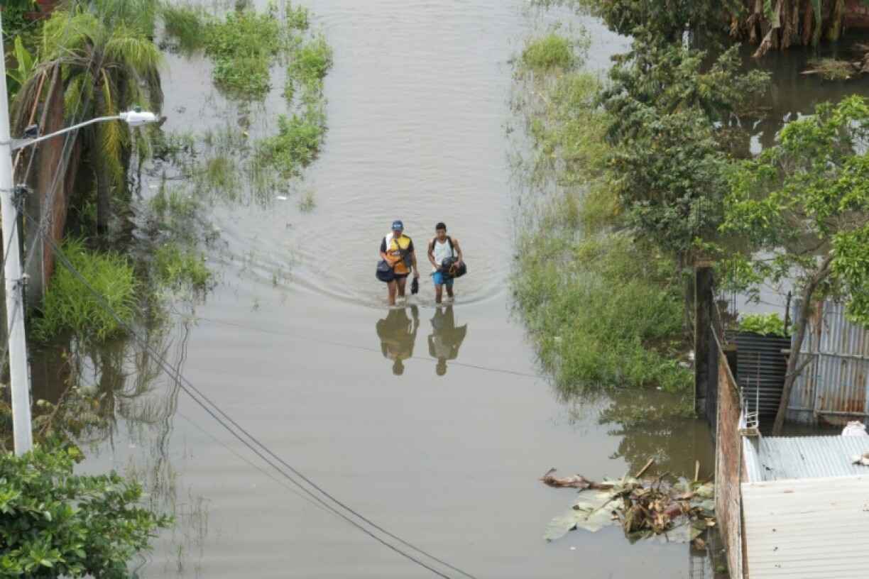 Des habitants lors d'une inondation à Milagro, en Equateur, le 12 mars 2023