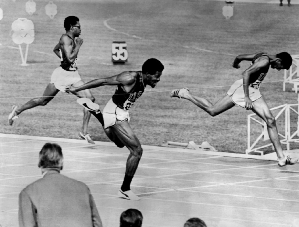L'Américain Lee Evans (c) franchit la ligne d’arrivée de la finale du 400 m devant ses compatriotes Larry James (d) et Ronald Freeman (g) aux Jeux de Mexico, le 19 octobre 1968