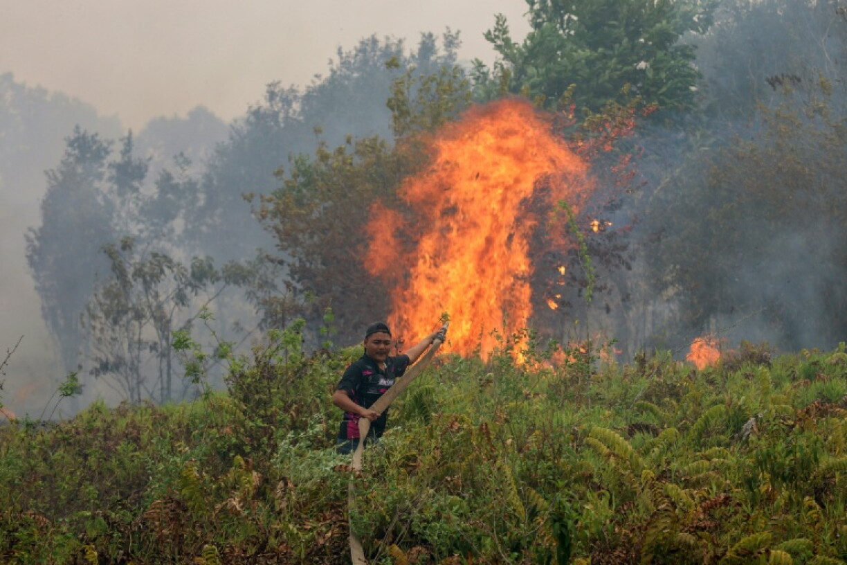 A firefighter extinguishing a fire at Sungai Tabuk village in Indonesia's Kalimantan Province on October 16