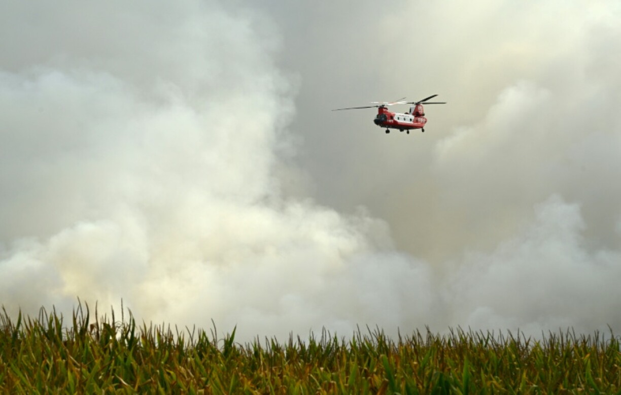 Un hélicoptère CH-47D Chinook du Service des pompiers ruraux (RFS) de Nouvelle-Galles du Sud, en Australie, survole la forêt de Luglon lors d'un incendie de forêt, dans le sud-ouest de la France, le 14 août 2026