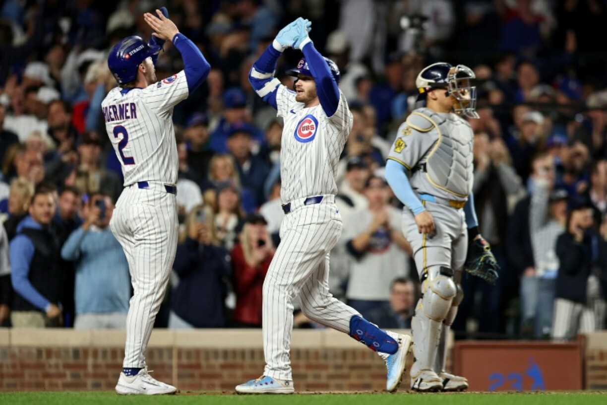 Nico Hoerner and Ian Happ of the Chicago Cubs celebrate Happ's first-inning home run in an MLB playoff win over the Milwaukee Brewers