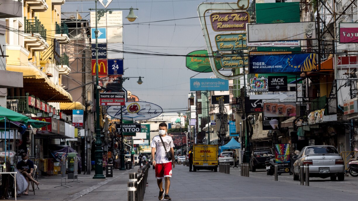 A man walks along Khao San Road -- a once popular tourist strip -- in Bangkok on November 1, 2021, as Thailand allows travellers vaccinated against the Covid-19 coronavirus to enter the country without the need for a two-week quarantine.
