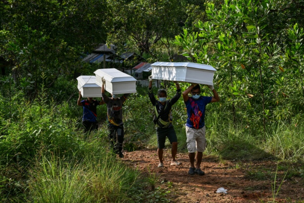 Des agents de l'agence philippine de gestion des catastrophes transportent des cercueils pour les victimes de l'incendie d'un ferry, à Coron, Palawan (Philippines), le 12 septembre 2026