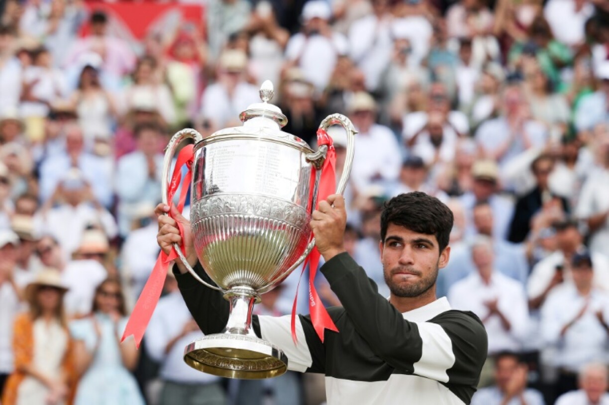 Spain's Carlos Alcaraz celebrates with the Queen's Club trophy