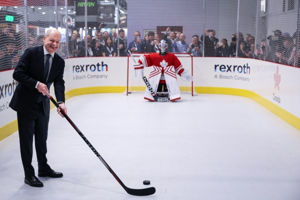 German Chancellor Olaf Scholz posed with an ice hockey stick as he toured the Hanover Fair