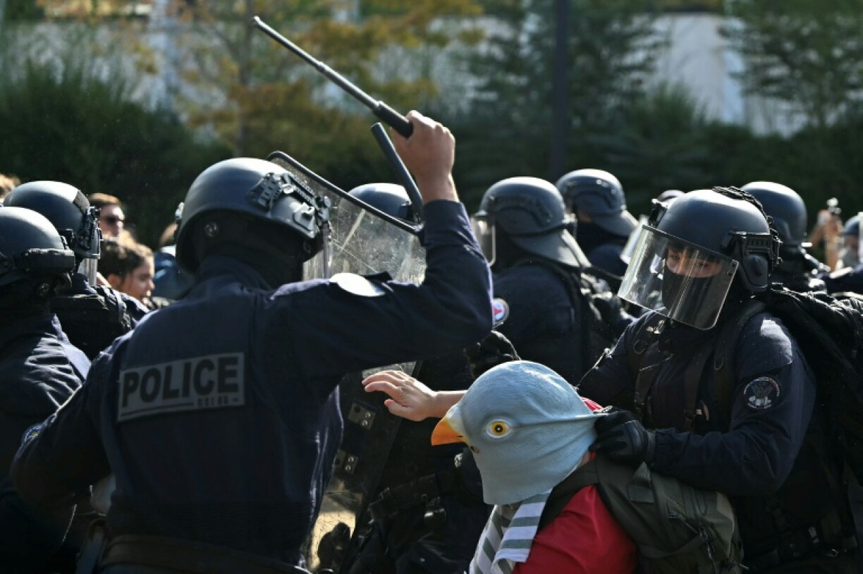 Riot police in Aubervilliers, outside Paris, with one brandishing his truncheon against a protester