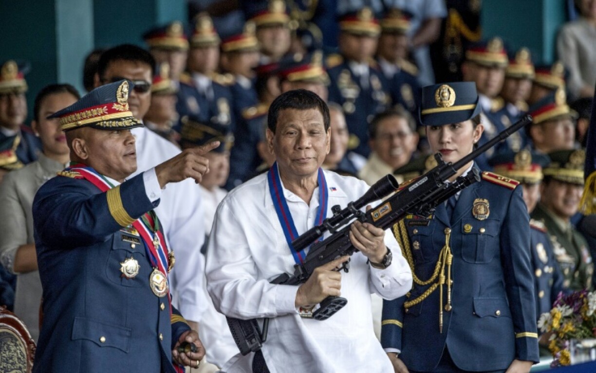 Former Philippine president Rodrigo Duterte, shown holding a rifle in 2018, faces charges over his drug war