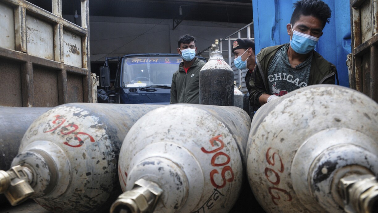 A man loads cylinders with medical oxygen for Covid-19 coronavirus patients outside an oxygen production plant in Kathmandu on May 13, 2021. Five people suffocated in a Nepal hospital after oxygen ran out this week, just the latest victims of a vicious Covid surge that risks devastating the impoverished country and its ill-equipped healthcare system.