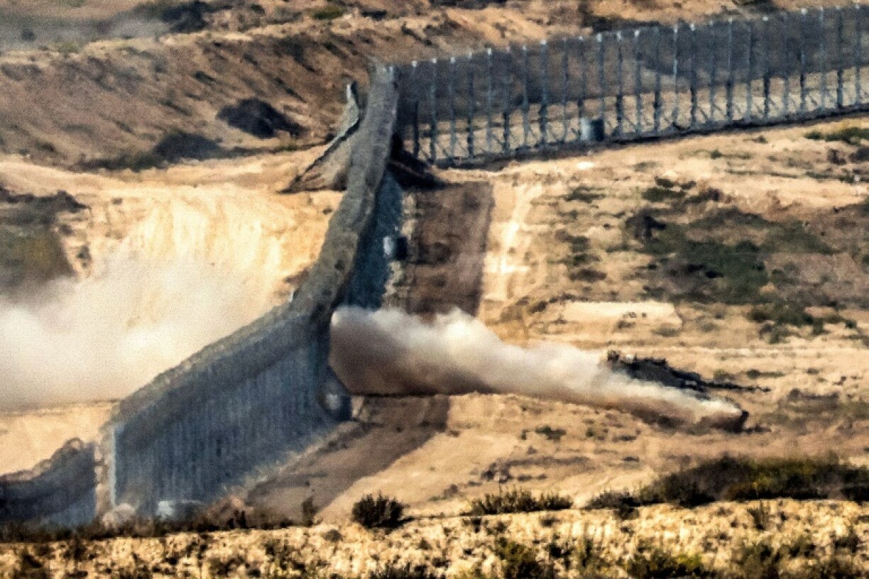 An Israeli army battle tank crosses a barbed wire fence at a position along the border with the Gaza Strip and southern Israel.