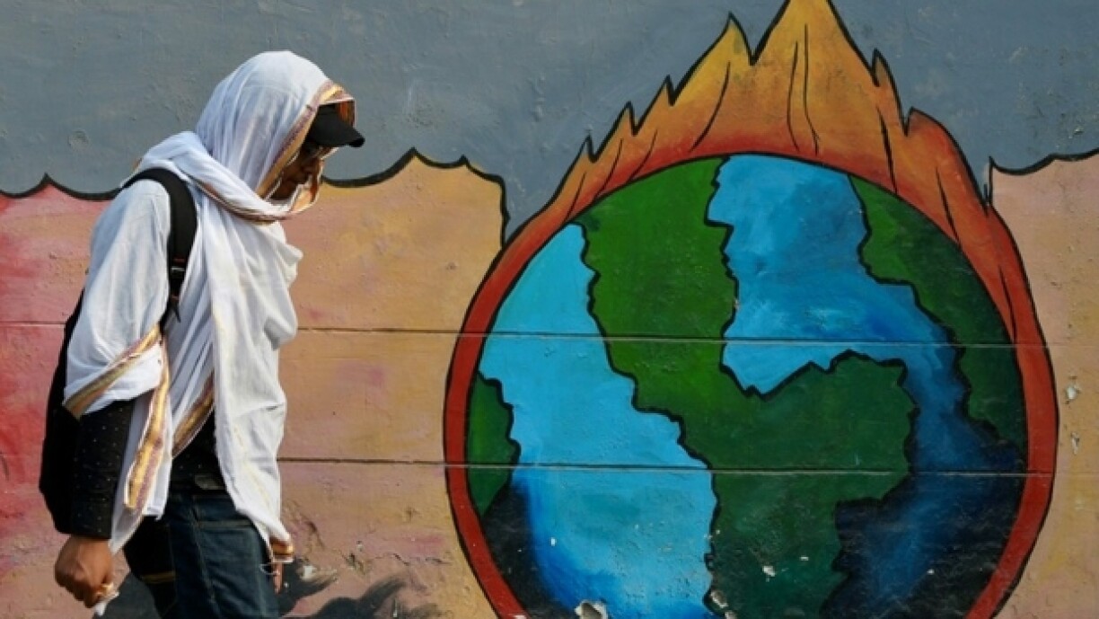 Un passant marche devant une peinture murale en pleine vague de chaleur à Varanasi, en Inde, le 9 juin 2025