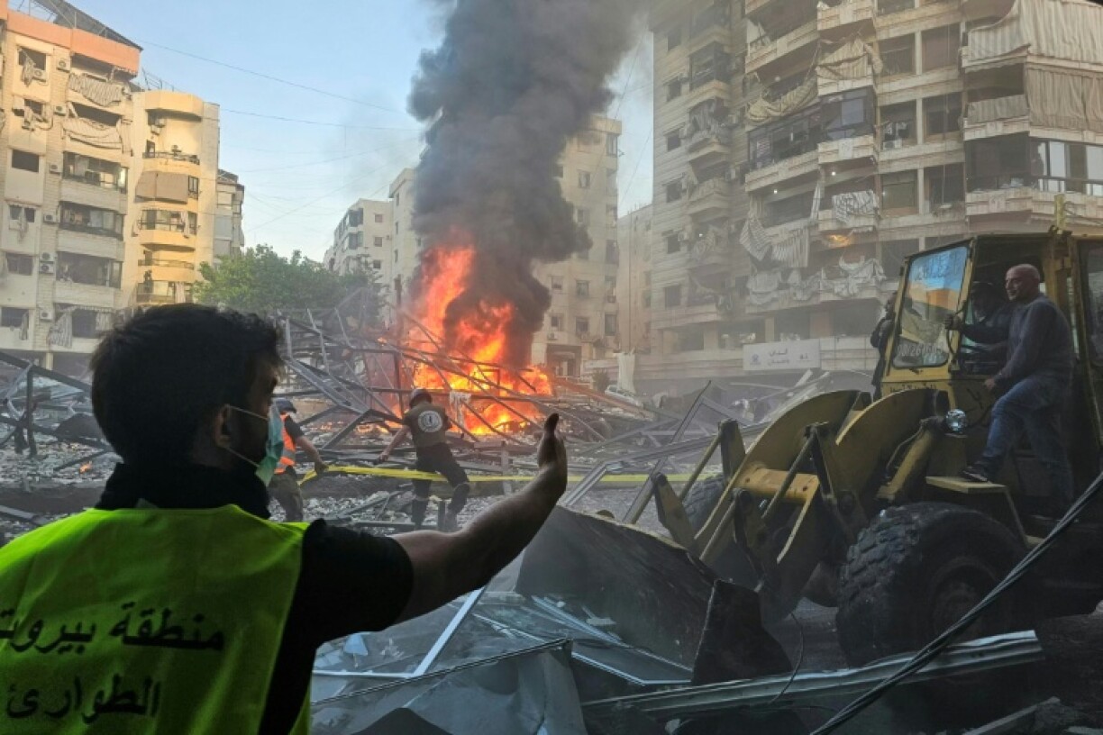 Lebanese emergency teams cordon off the blazing rubble of a building hit by an Israeli air strike in south Beirut. perimeter of a fire at the site of Israeli strikes following evacuation orders, in Beirut's southern suburb on April 27, 2025.