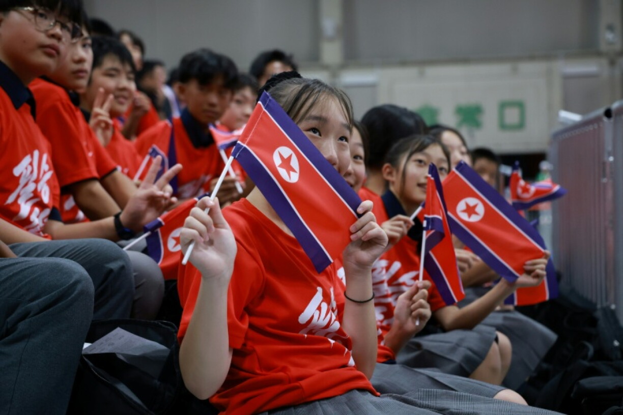 North Korea supporters wave flags during the men's 60kg weightlifting final at the 2026 Asian Games in Nagoya on September 24