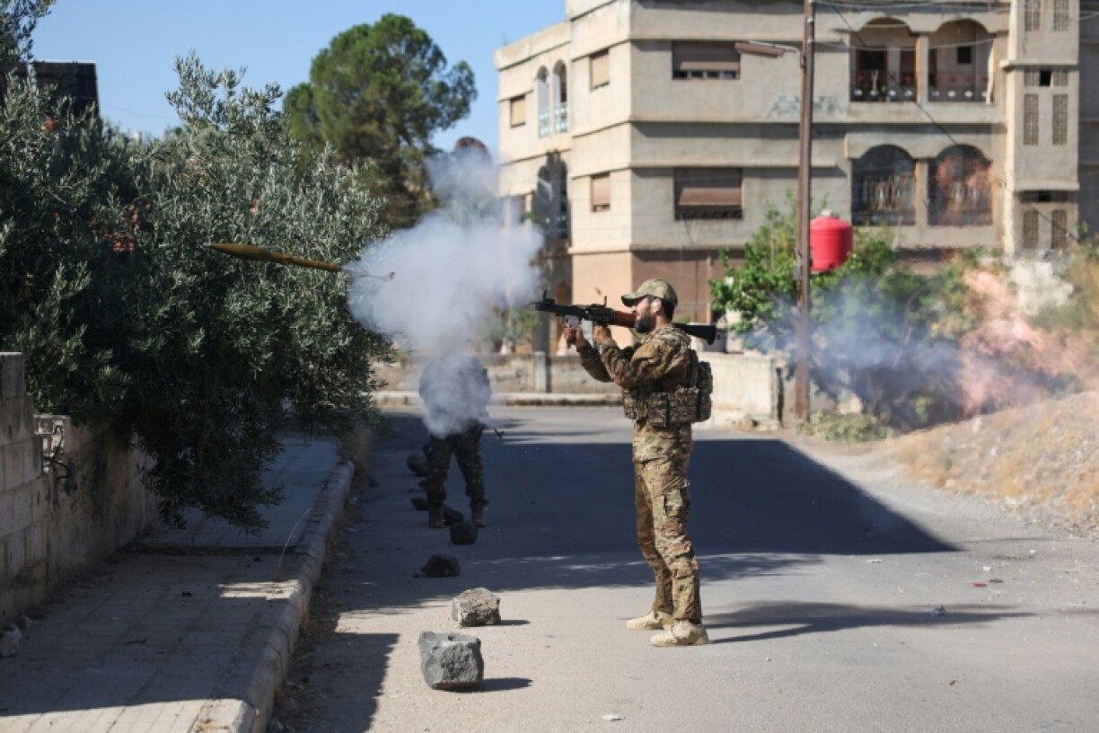 A Syrian government loyalist fires a shoulder-launched weapon in Sweida