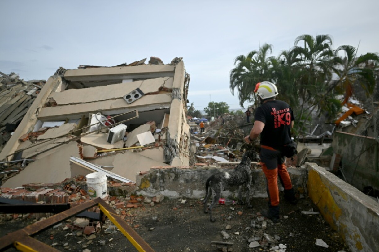 Un sauveteur espagnol et son chien de sauvtegae devant un immeuble effondré après le double séisme au Venezuela, le 3 juillet 2026 à Caraballeda, dans l’État de La Guaira