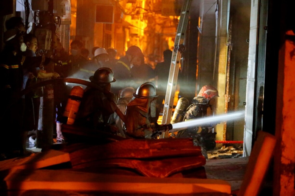 Des pompiers interviennent sur l'incendie d'un immeuble d'habitation dans la capitale vietnamienne Hanoï, dans la nuit du 12 au 13 septembre 2023