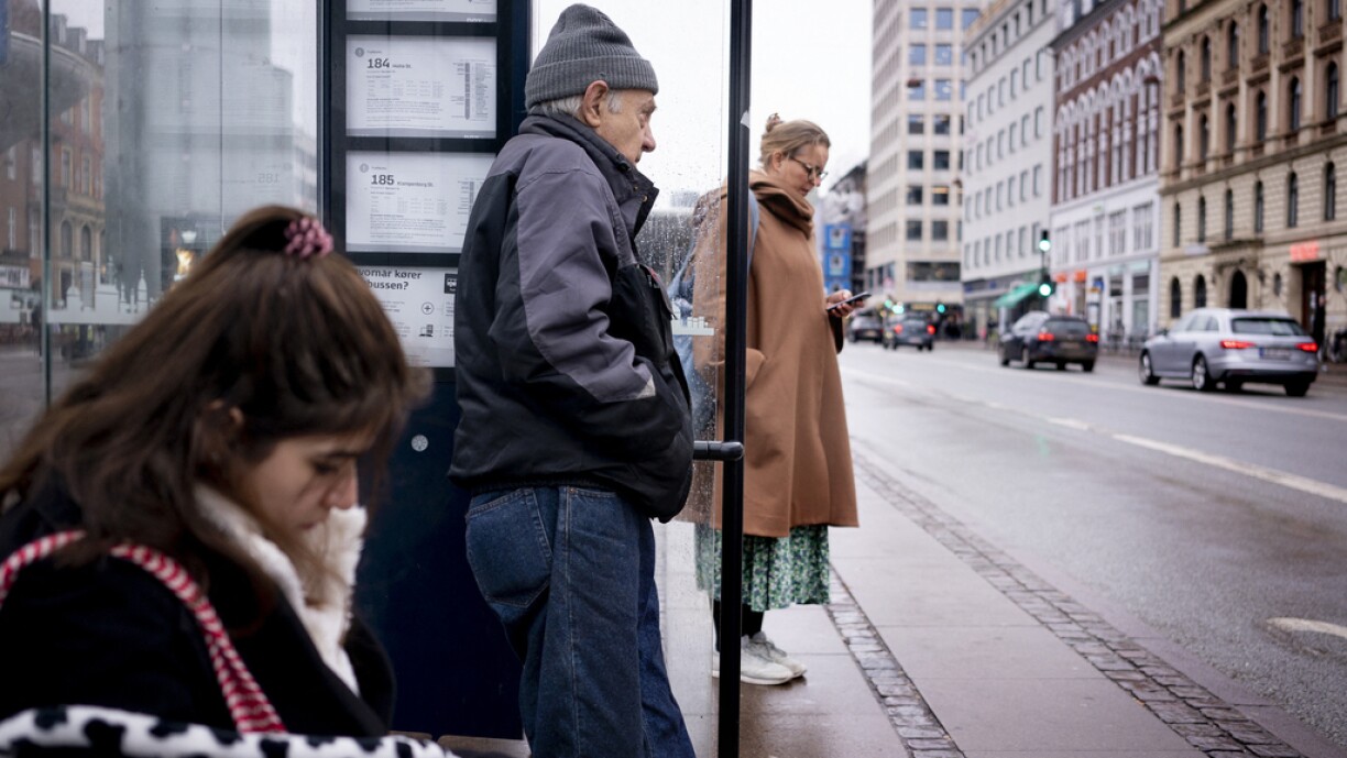 Commuters wait at a bus stop in Copenhagen on February 1, 2022, as Denmark becomes the first EU country to lift coronavirus restrictions despite record case numbers, citing its high vaccination rates and the lesser severity of Omicron variant. February 1, 2022 de facto lifts all domestic restrictions, including the use of a vaccine pass, mask-wearing and early closings for bars and restaurants. Some border measures will remain in place for another four weeks, including tests and/or quarantine depending on travellers' immunity status.