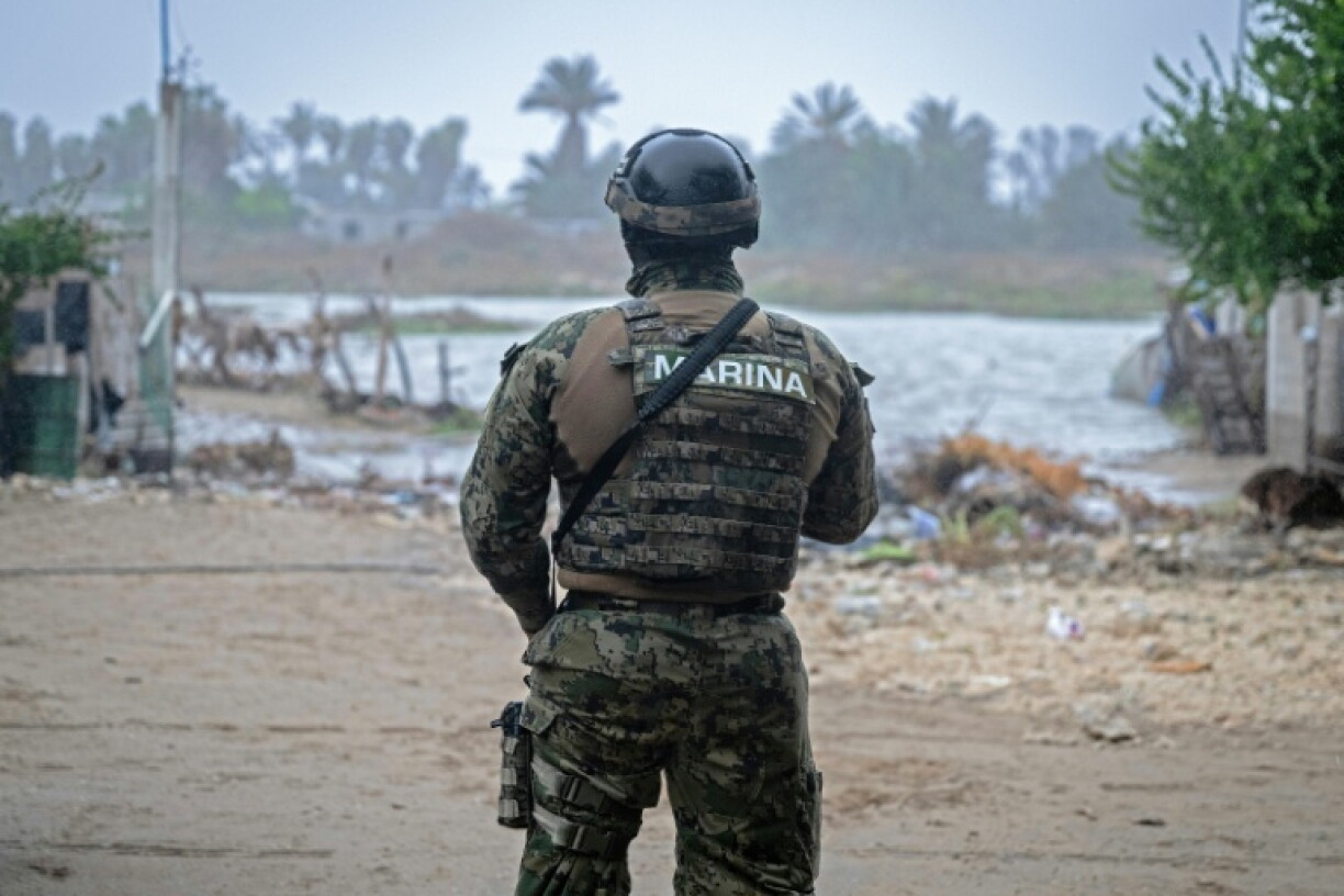 A member of the Mexican Navy stands near a flooded area in the town of Puerto San Carlos, in Mexico's Baja California Sur state, as Hurricane Polo batters the region