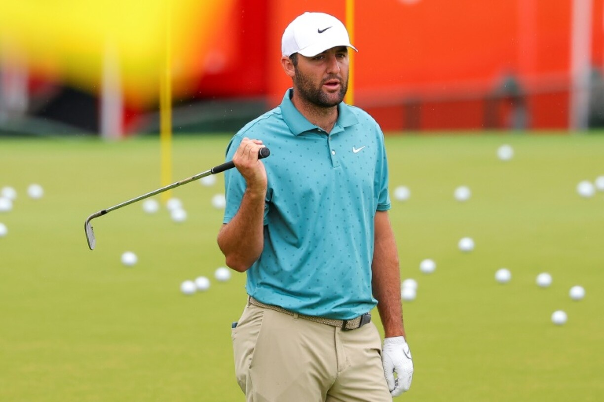 World number one Scottie Scheffler of the United States warms up at the driving range on the rainy first practice day for the 107th PGA Championship at Quail Hollow