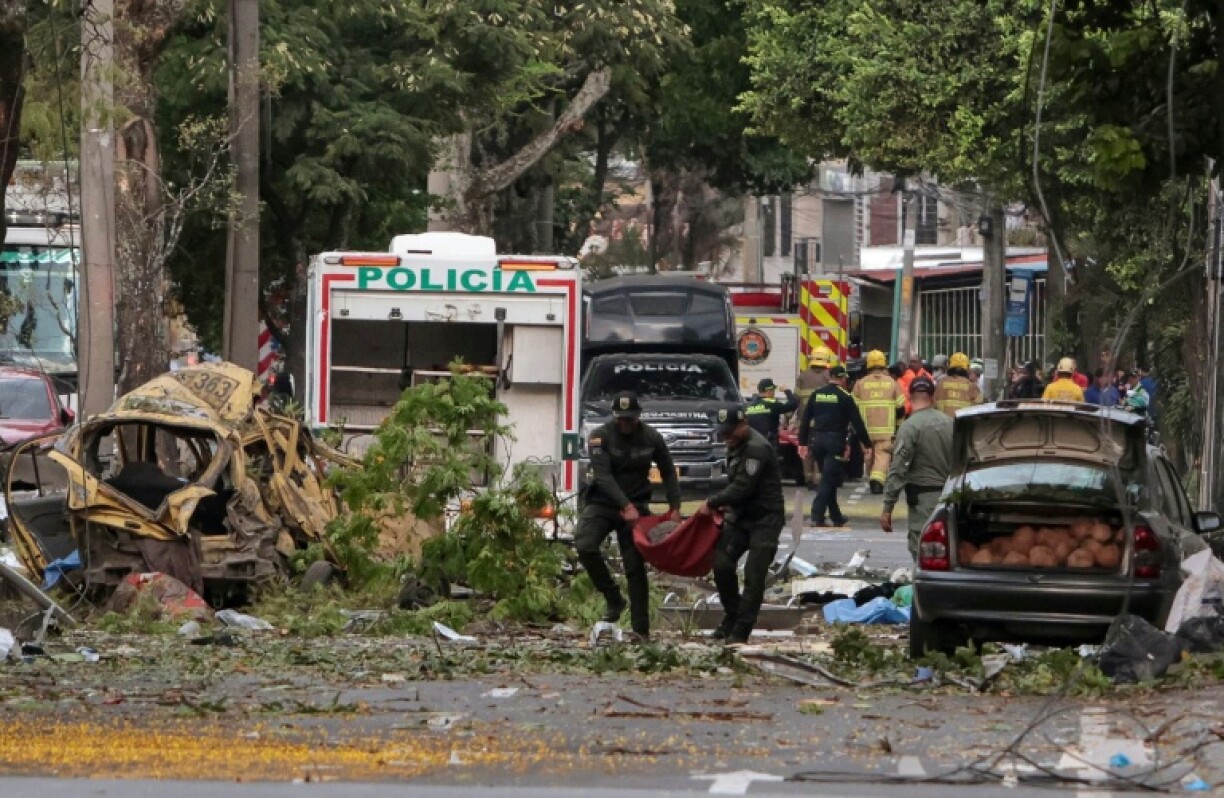 Police officers carry debris from the site of a bomb explosion in Cali, Colombia.