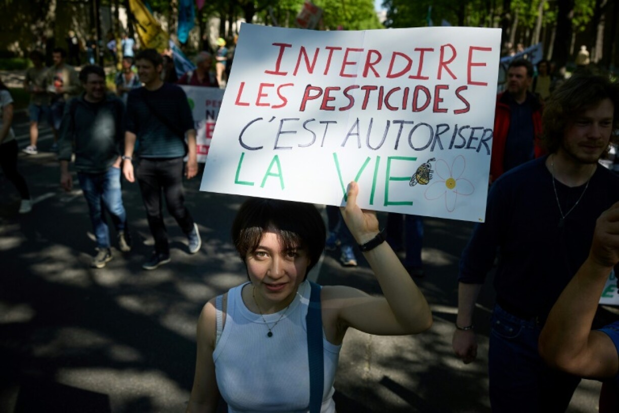 Une manifestante tient une pancarte sur laquelle on peut lire