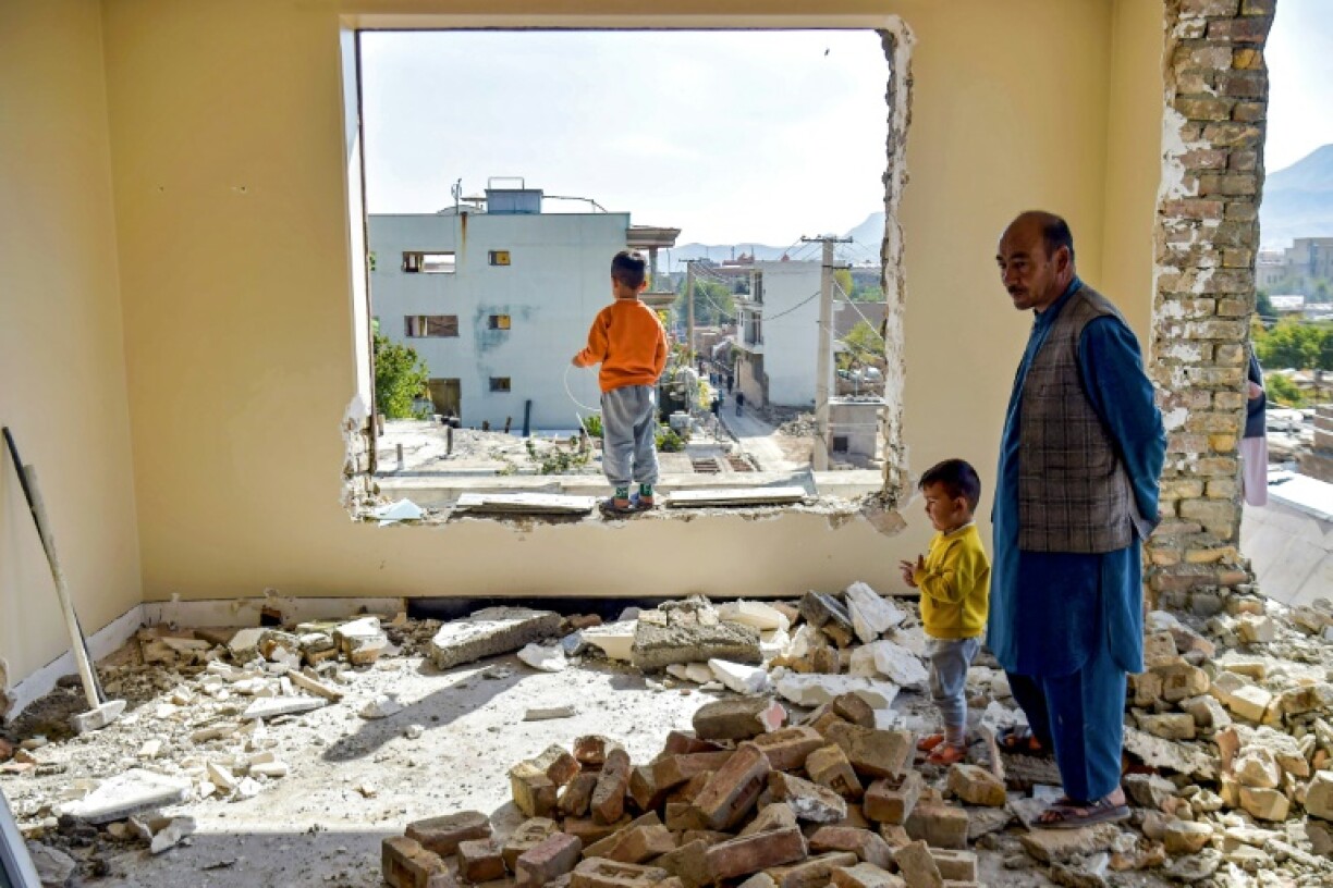 Mohammed Naeem stands with his children amid the rubble of his Kabul home, due for demolition under a redevelopment plan by Taliban authorities