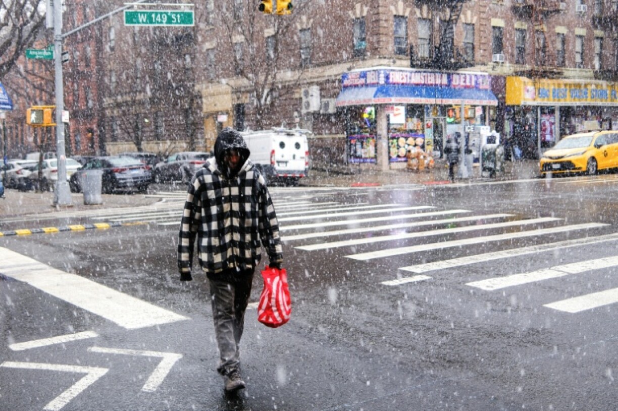 Un passant sous la neige dans une rue de New York, le 17 janvier 2026