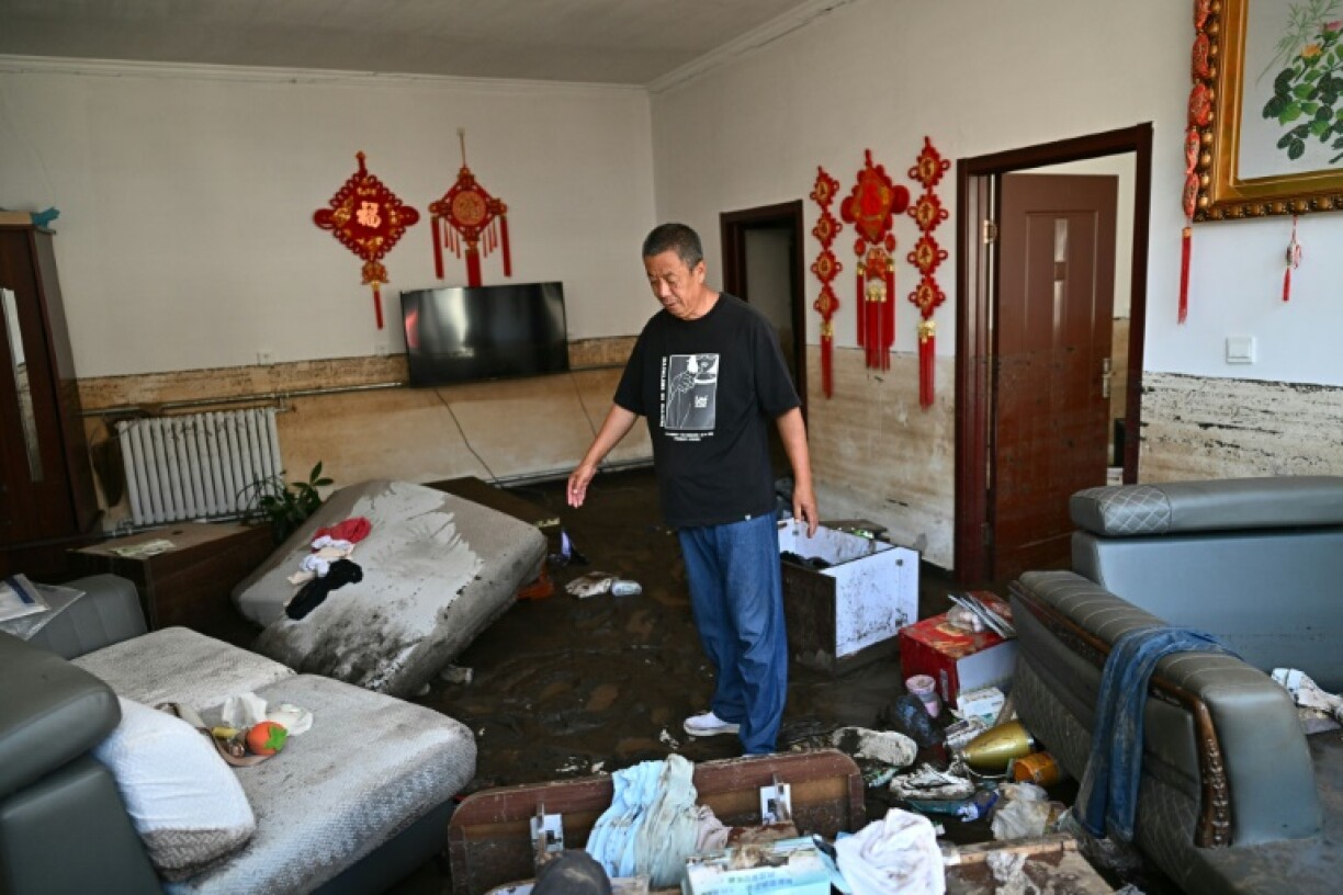 Wang, 57, shows his flood damaged house after the recent heavy rains in Huairou district