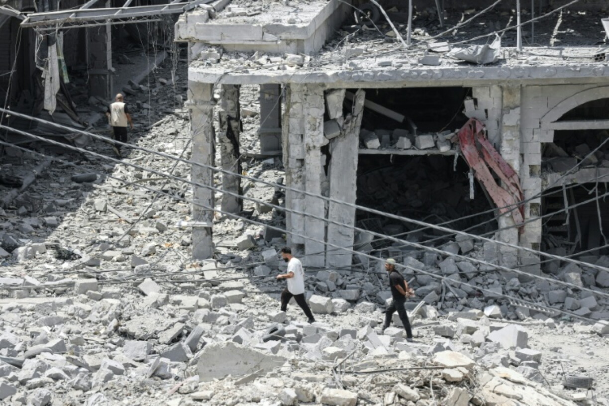 Des habitants déplacés, de retour à Nabatiyé, se fraient un chemin au milieu des décombres d'un immeuble détruit, le 15 juin 2026 dans le sud du Liban