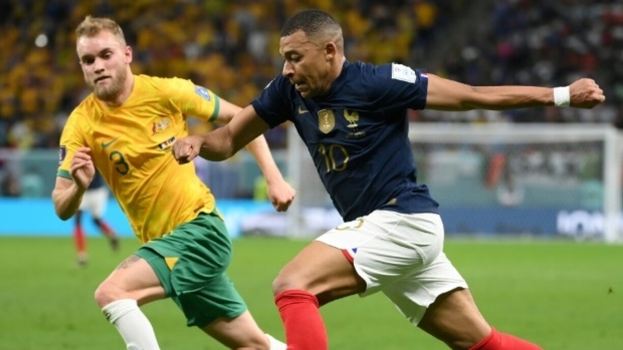 L'attaquant frnaçais Kylian Mbappé (d) devant le milieu australien Nathaniel Atkinson lors de France-Australie au Mondial-2022, à Al-Wakhra, au sud de Doha, le 22 novembre 2022