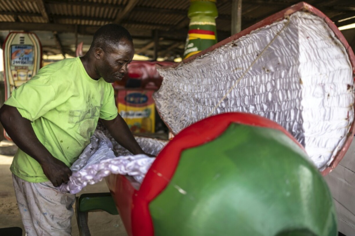 Eric Adotey Kpakpo, 49 ans, également connu sous le nom d’Erico, aménage l’intérieur d’un cercueil en forme de piment, conçu pour un agriculteur décédé, dans son atelier de menuiserie à Accra, au Ghana, le 17 août 2026