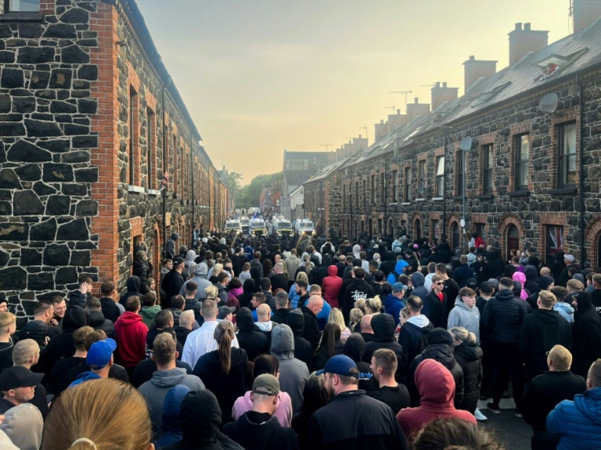 Protestors stand in front police vehicles blocking a street during an angry demonstration in Ballymena, Northern Ireland