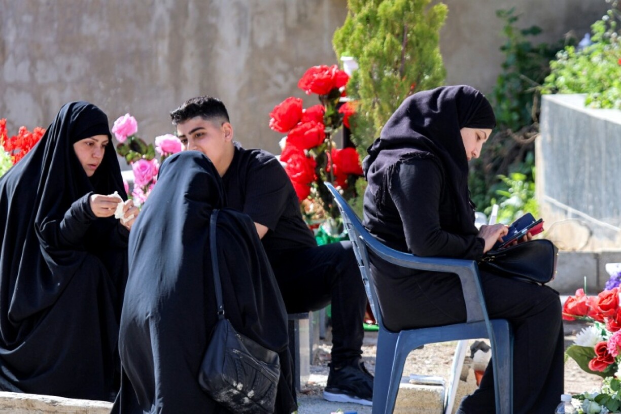Des fidèles se recueillent sur les tombes de leurs proches tués pendant la guerre entre le Hezbollah et Israël, à Kfar Kila, dans le sud du Liban, le 31 mars 2025 au premier jour de la fête de l'Aïd el-Fitr