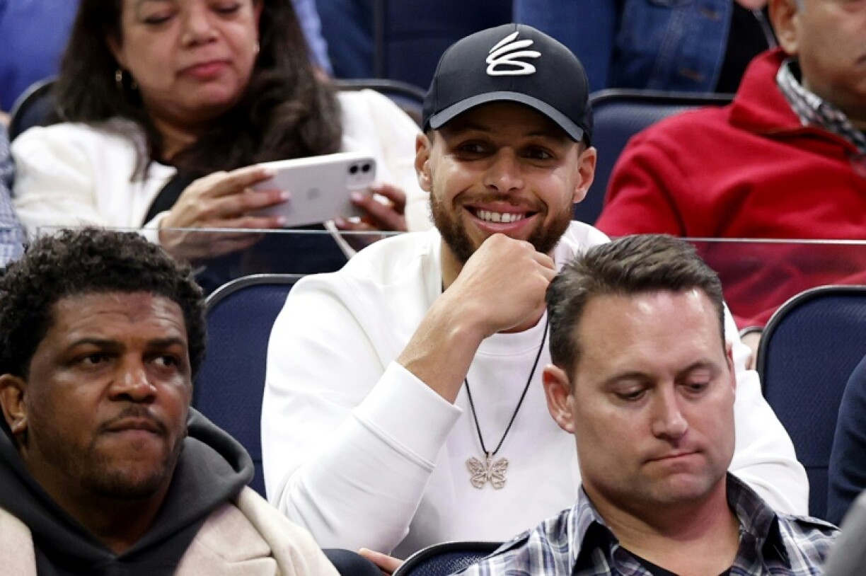 La star des Warriors Steph Curry (casquette) assiste à un match de NCAA au Chase Center, le 24 mars 2022 San Francisco