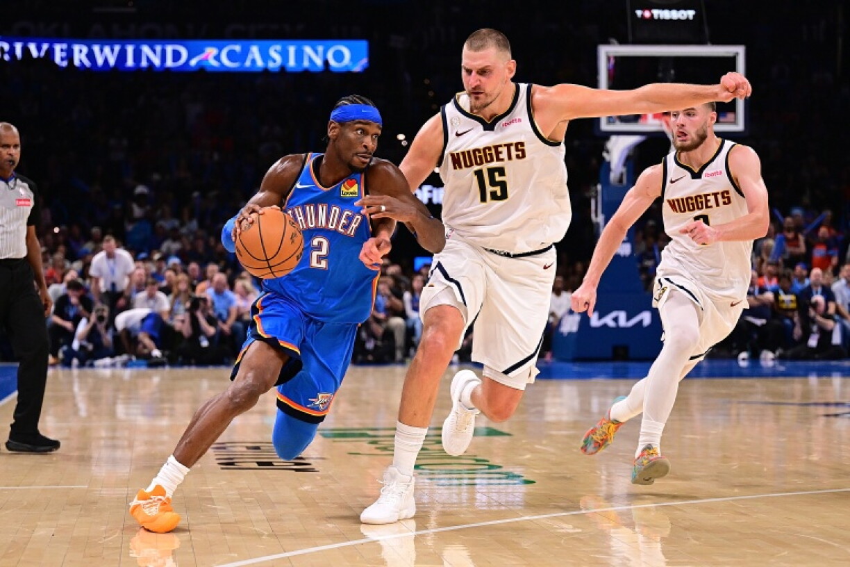 Shai Gilgeous-Alexander (g) tente de déborder Nikola Jokic lors du match NBA du Thunder contre les Denver Nuggets, le 22 octobre 2026 à Oklahoma City