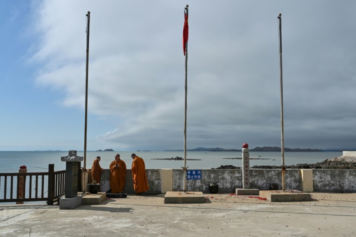 Buddhist monks look over the sea at a temple on Pingtan island, the closest point in China to Taiwan’s main island, on Thursday