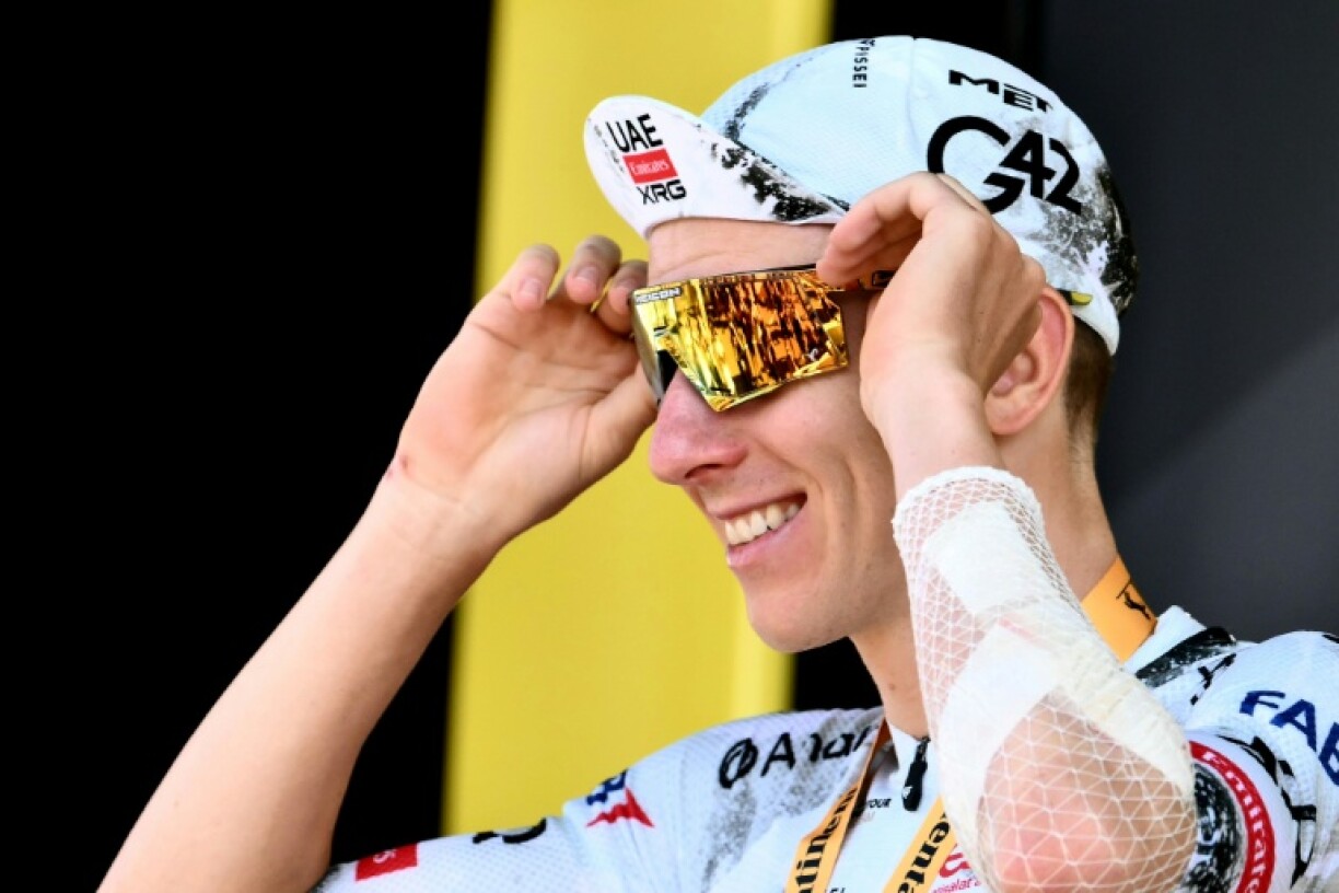 Tadej Pogacar celebrates on the podium after winning the 13th stage