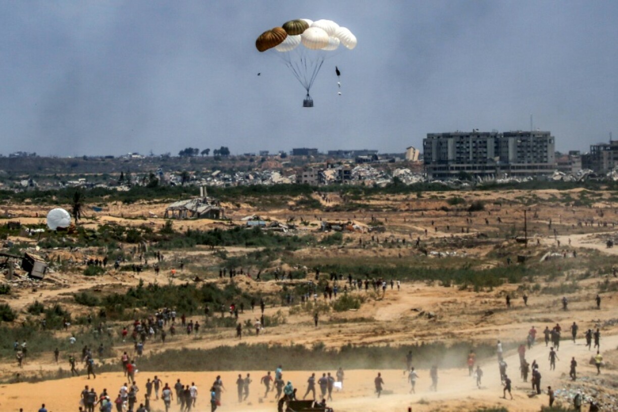 Des Palestiniens se précipitent pour récupérer de l'aide humanitaire parachutée au-dessus de Nousseirat, dans le centre de la bande de Gaza, le 5 août 2025
