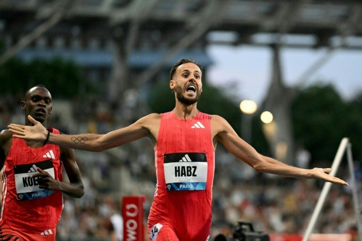 France's Azeddine Habz (C) celebrates as he crosses the finish line to win the men's 1500m