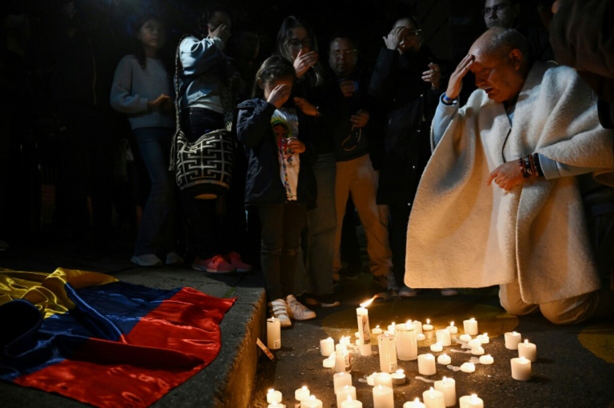 People pray as they light candles outside the Clinic Fundacion Santa Fe, where Senator Miguel Uribe Turbay is receiving medical treatment