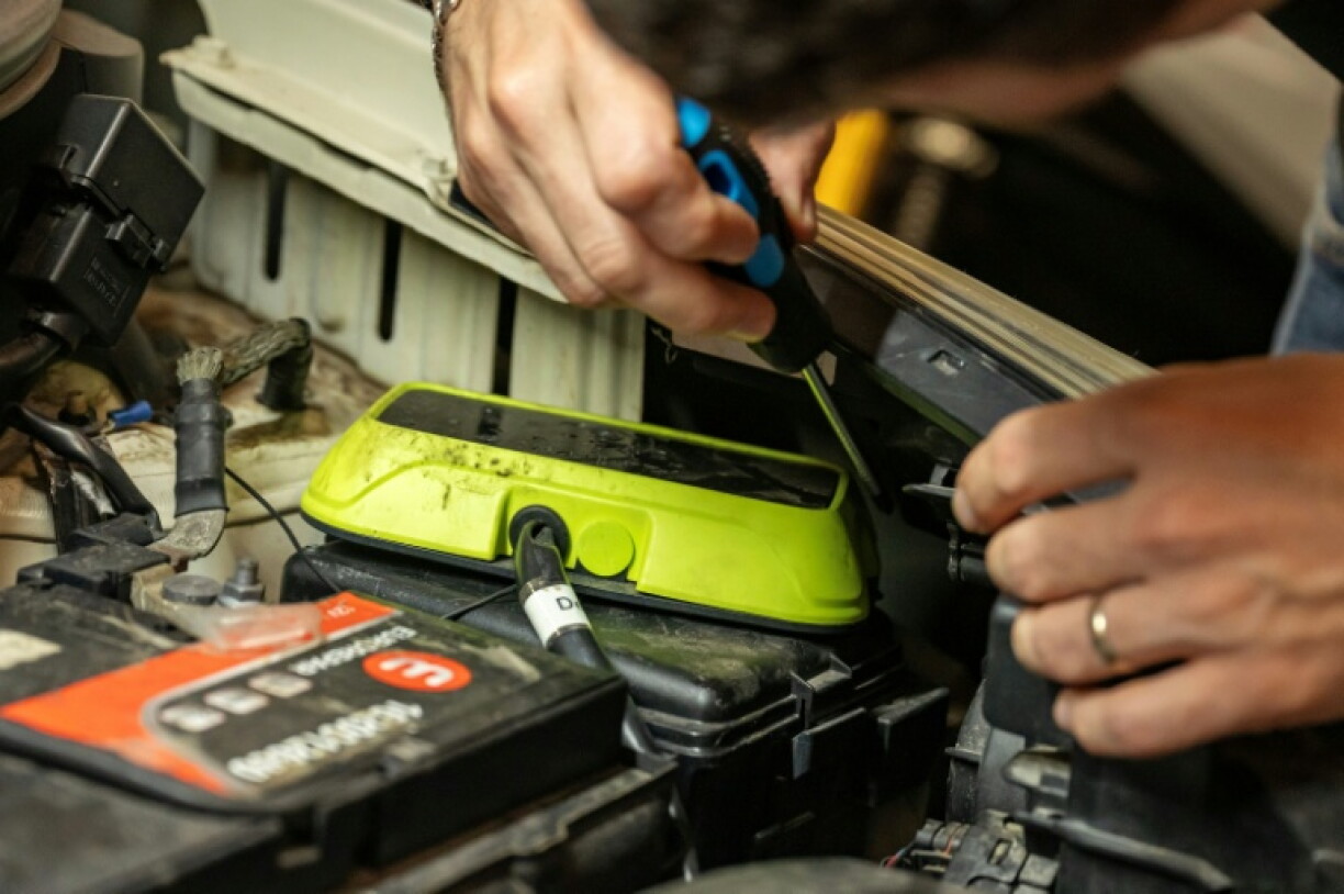Un mécanicien installe sur un moteur un boîtier de conversion au bioéthanol dans un garage à Marseille, le 18 septembre 2026