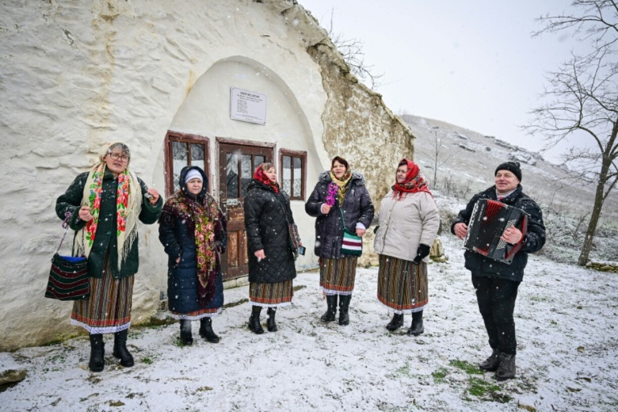 Des femmes du village de Rogojeni, en costumes traditionnels moldaves, chantent des chants de Noël près d'une maison-musée