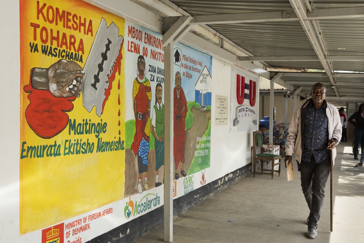 Un Massaï passe devant une fresque murale appelant à l'abolition des mutilations génitales féminines (MGF) et des mariages d'enfants, dans un couloir d'un hôpital de Narok (Kenya), le 3 décembre dernier. Les mutilations génitales féminines (MGF) restent une pratique profondément ancrée dans certains villages. Une infirmière locale a déclaré à l'AFP qu'environ 80 % des filles sont encore concernées, malgré l'interdiction de cette pratique en 2011.
