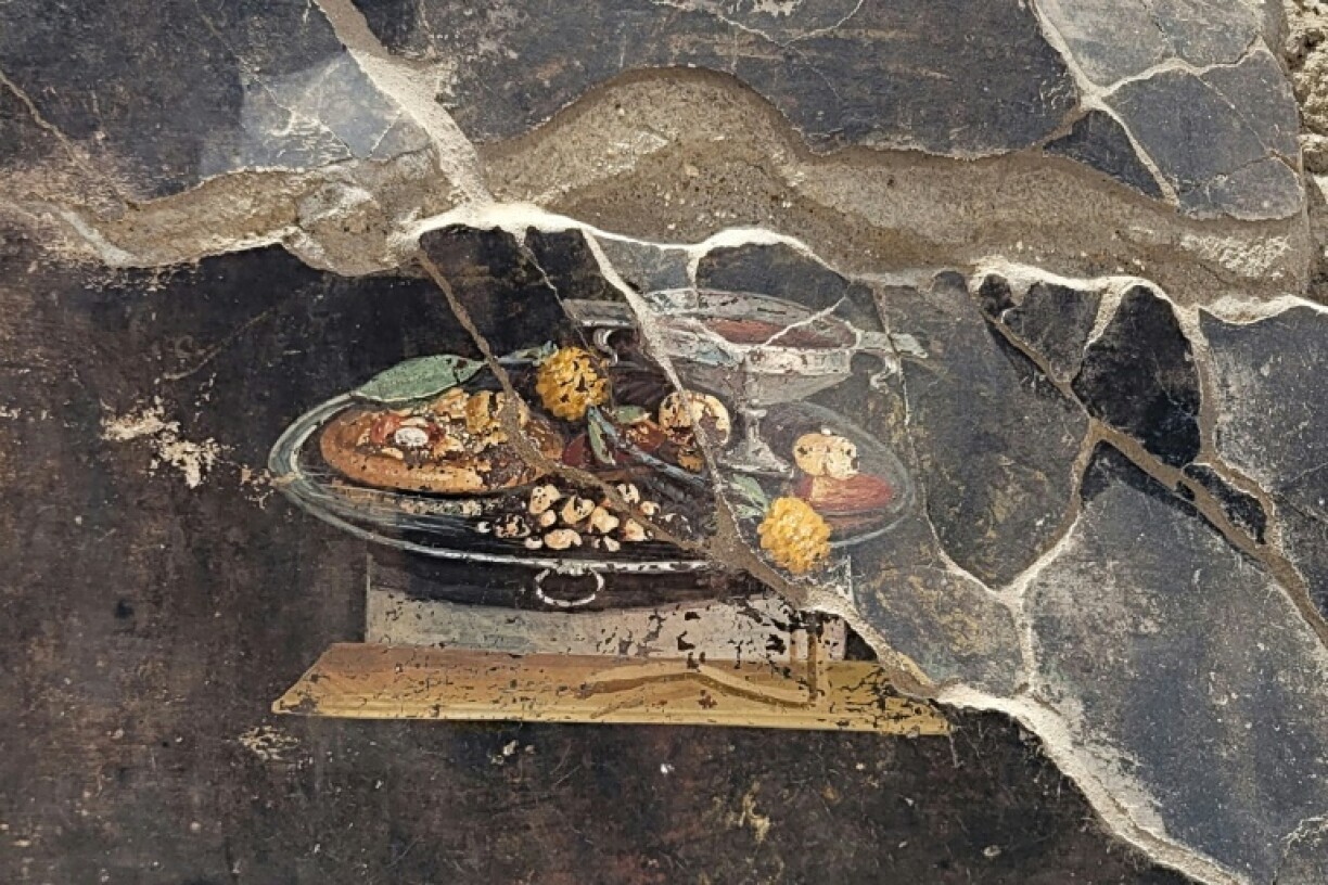 Image diffusée par le Parc archéologique de Pompéi le 25 juin 2023 d'une fresque datant d'il y a 2.000 ans représentant une coupe de vin et ce qui ressemble à s'y méprendre à une pizza