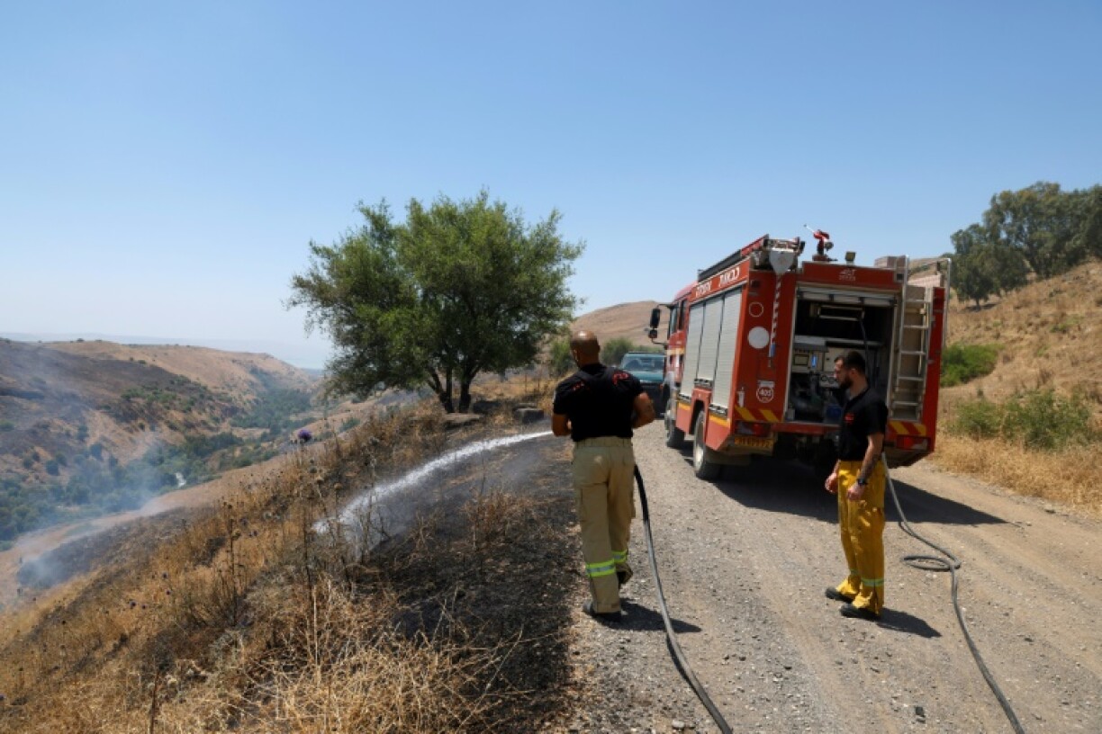 Des pompiers israéliens éteignent un feu de broussailles causé par des tirs de roquettes depuis le Liban, le 11 juin 2024 près de Had Nes, dans le nord d'Israël