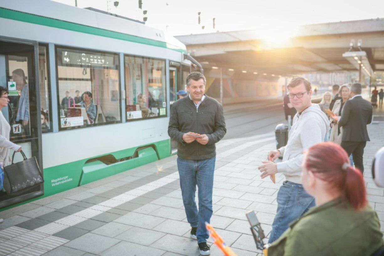 Sven Schulze (au centre), ministre-président de Saxe-Anhalt et candidat tête de liste du parti conservateur CDU aux élections régionales, parle avec un passant près de la gare centrale de Magdebourg, dans l'est de l'Allemagne, le 27 août 2026