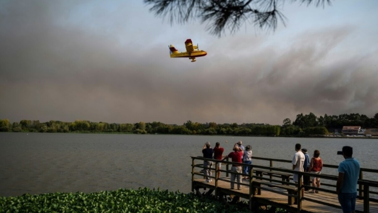 Des habitants observent un Canadair espagnol pendant un feu de forêt à Pateira de Fermentelos (Portugal), le 17 septembre 2024