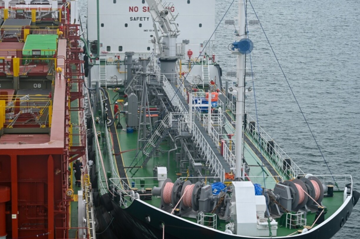A bunkering barge (R) supplies bio-methanol fuel to a container ship in Singapore. Three firms have been licensed to start supplying methanol in the port city from next year to help cut shipping carbon emissions
