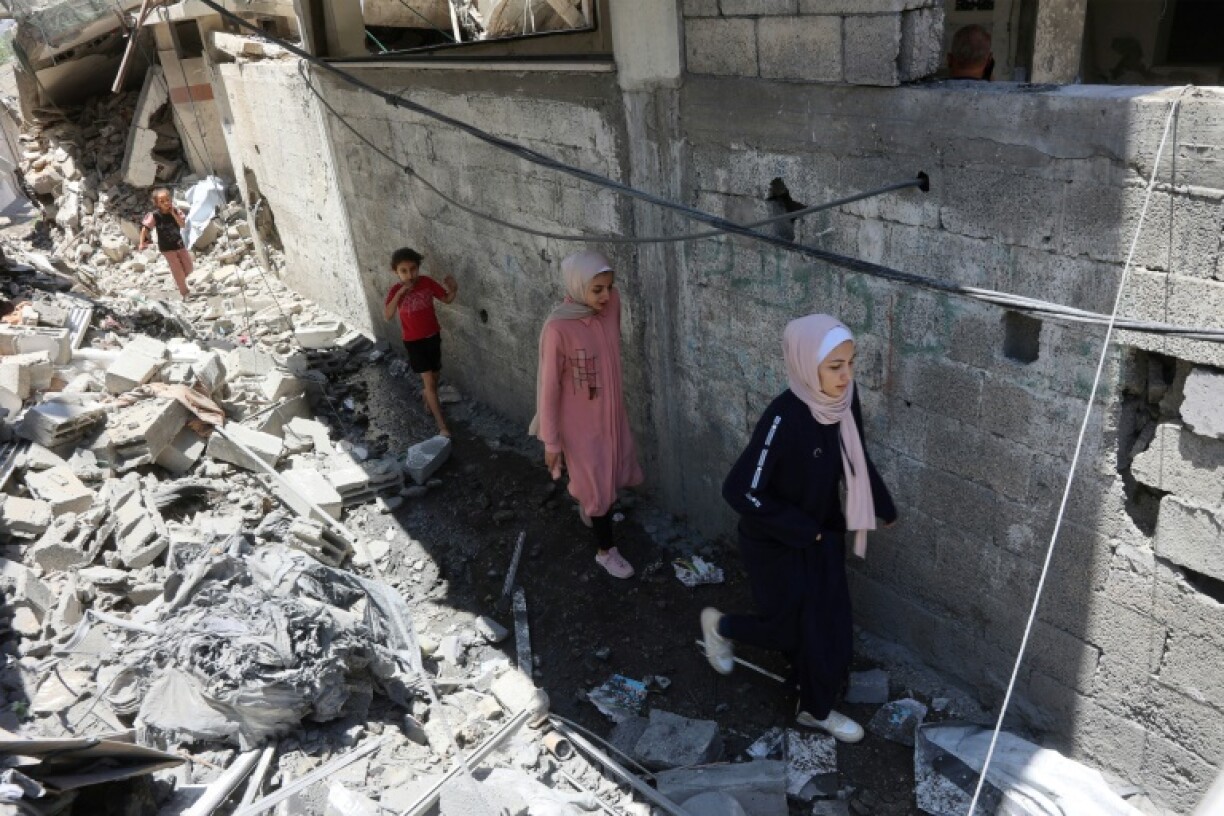 Palestinians children walk amid the rubble of a home that was targeted in an Israeli strike in Jabalia on Monday